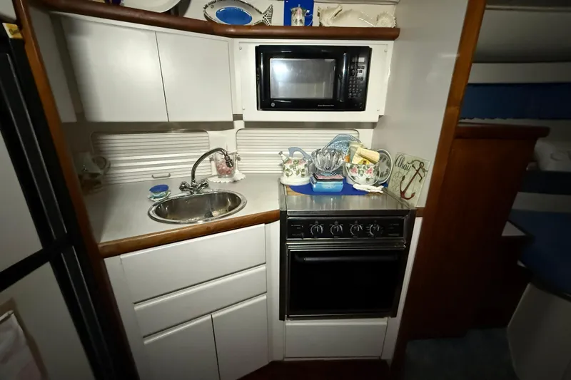 Slide: The Image of Compact kitchen in 1994 Carver 390 Cockpit Motor Yacht with sink, stove, and microwave. - 14