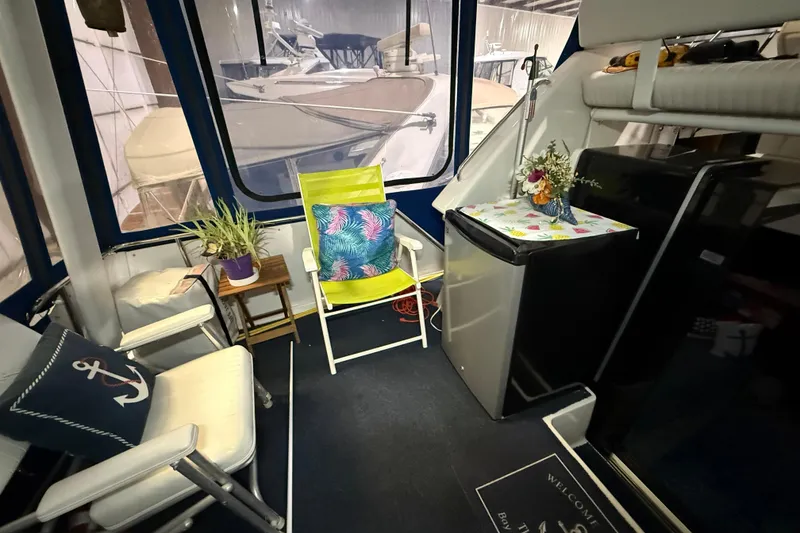 Slide: The Image of Interior of 1994 Carver 390 Cockpit Motor Yacht with seating, plants, and mini fridge. - 19