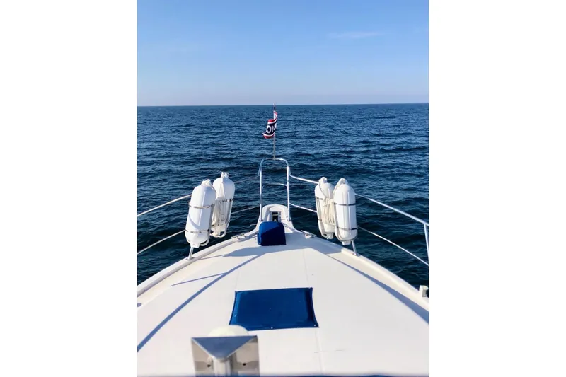 Slide: The Image of Bow view of 1994 Carver 390 Cockpit Motor Yacht cruising on open sea. - 2