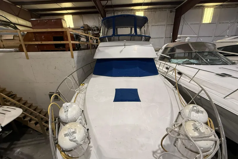 Slide: The Image of 1994 Carver 390 Cockpit Motor Yacht in indoor storage, featuring blue accents and safety buoys. - 21
