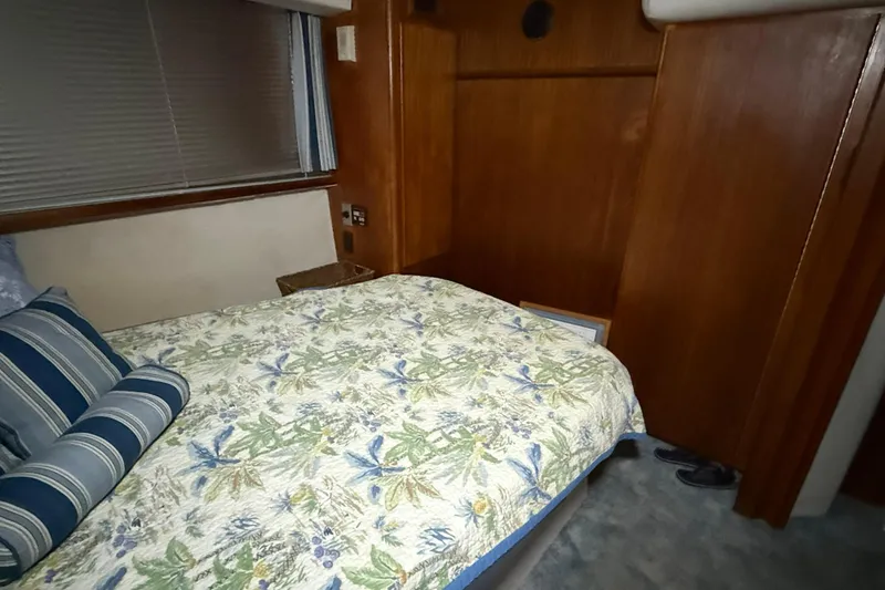 Slide: The Image of Cozy bedroom in 1994 Carver 390 Cockpit Motor Yacht with floral bedding and wood paneling. - 5
