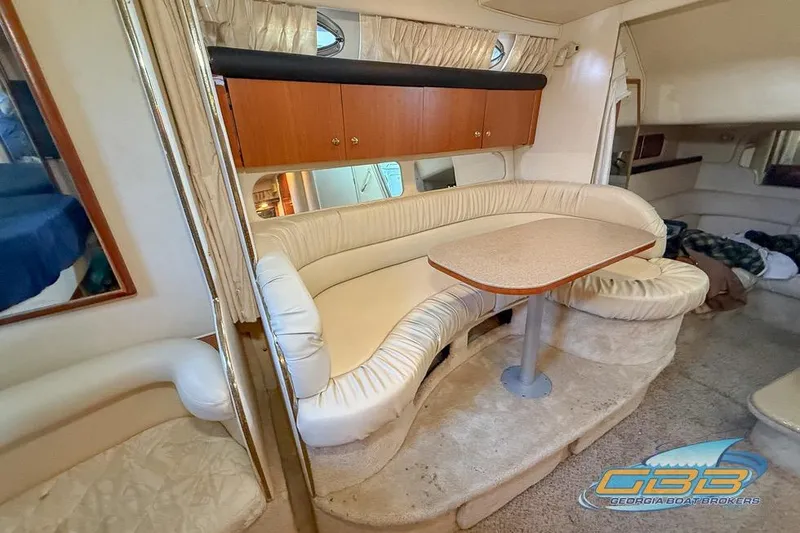 Slide: The Image of Interior of 2000 Sea Ray 340 Sundancer with curved seating and wooden cabinetry. - 17