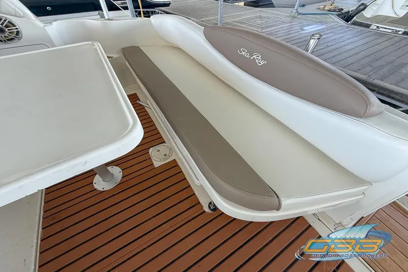 Slide: The Image of 2000 Sea Ray 340 Sundancer interior with cushioned seating and wooden deck. - 22
