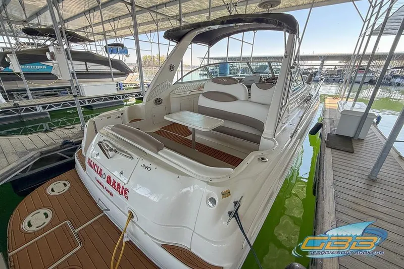 Slide: The Image of 2000 Sea Ray 340 Sundancer docked in a marina, showcasing spacious seating and elegant design. - 24