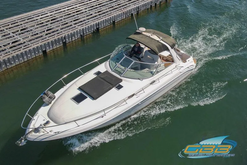Slide: The Image of 2000 Sea Ray 340 Sundancer cruising on water near a dock. - 26