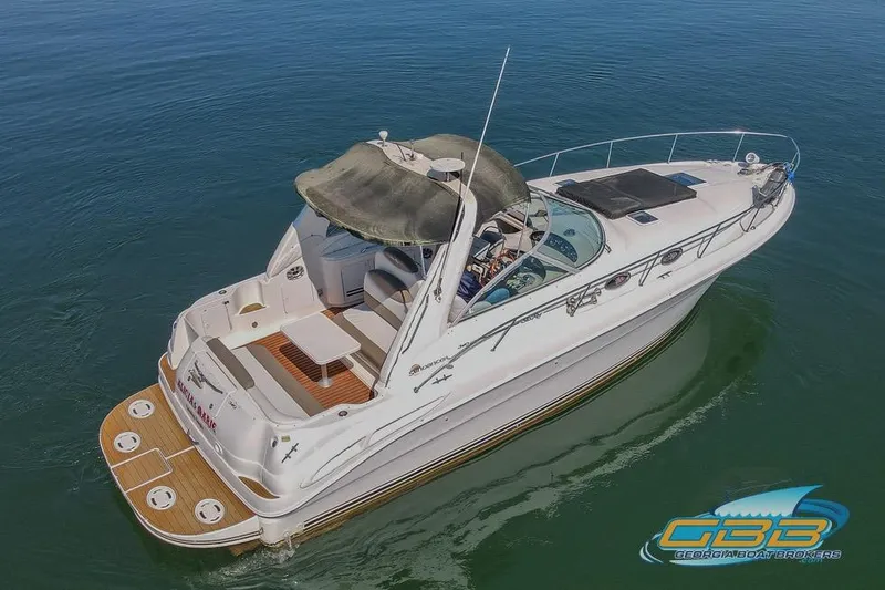 Slide: The Image of 2000 Sea Ray 340 Sundancer yacht on calm water, featuring spacious deck and sleek design. - 31