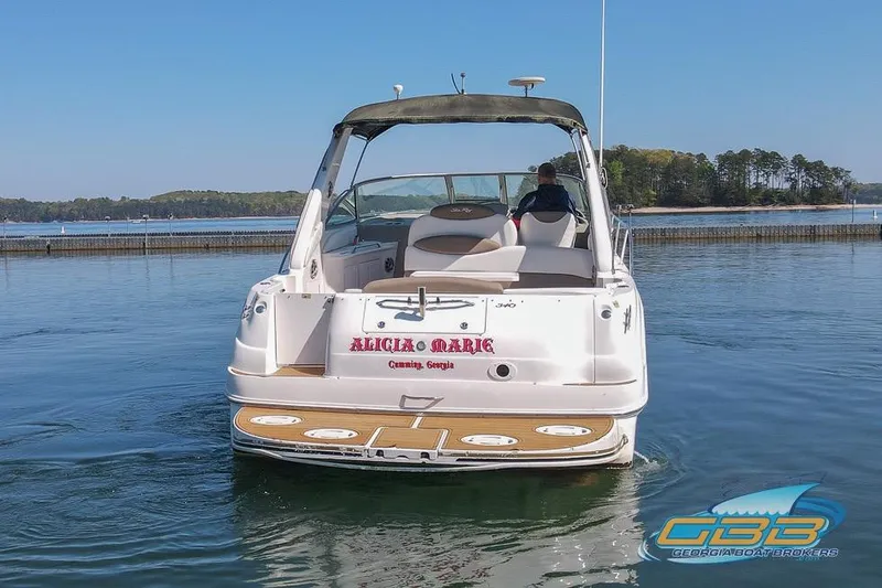 Slide: The Image of 2000 Sea Ray 340 Sundancer boat on calm water, rear view, with scenic background. - 34