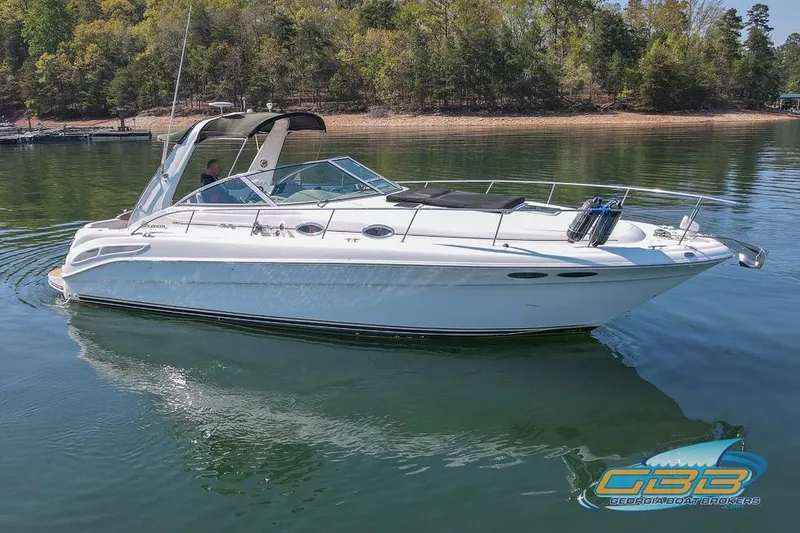 Slide: The Image of 2000 Sea Ray 340 Sundancer cruising on a serene lake with lush forest backdrop. - 35