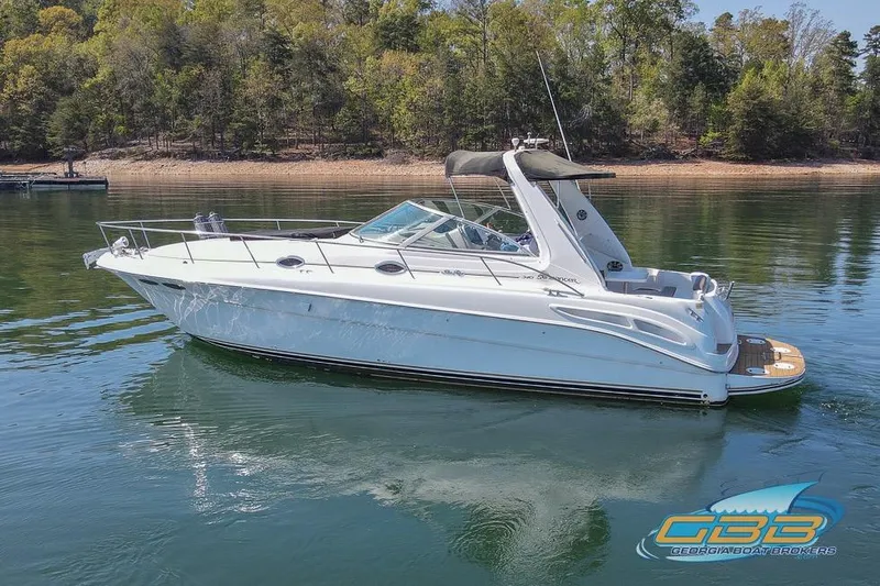 Slide: The Image of 2000 Sea Ray 340 Sundancer boat on calm water with forested shoreline. - 37