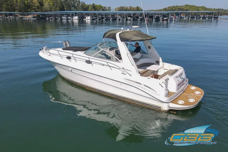 Slide: The Image of 2000 Sea Ray 340 Sundancer cruising on a calm lake near a marina. - 39