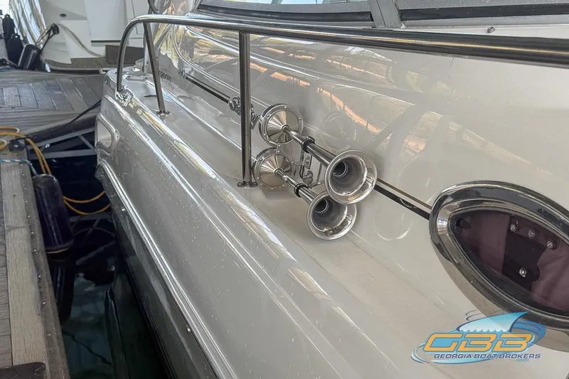 Slide: The Image of 2000 Sea Ray 340 Sundancer boat docked, featuring chrome horns and sleek design. - 47