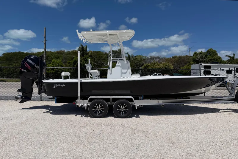 The Image of 2012 Yellowfin 24 Bay boat on trailer under clear blue sky. - 1