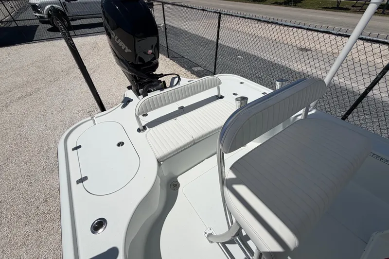 Slide: The Image of 2012 Yellowfin 24 Bay boat with seating and Mercury engine, parked near a fence. - 3