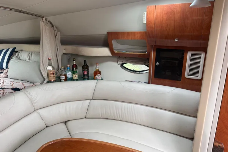 Slide: The Image of Interior of 2007 Doral Intrigue boat with curved seating and mini bar setup. - 18