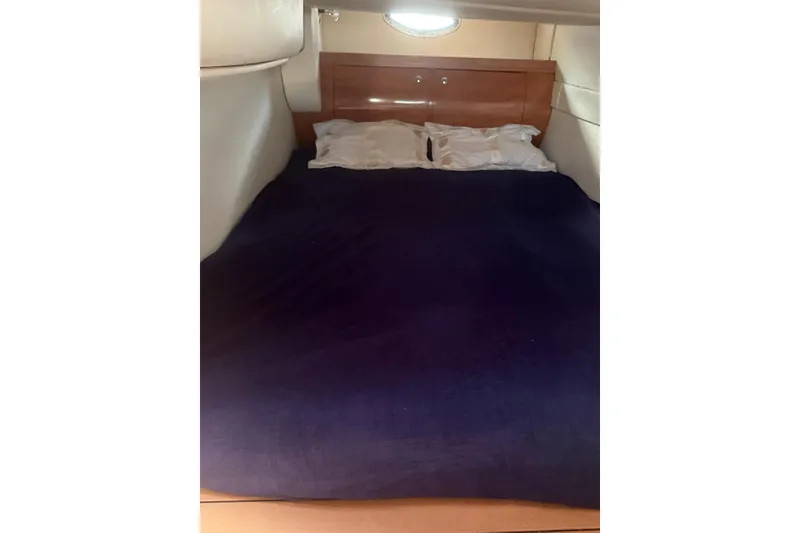Slide: The Image of Cozy cabin bed in 2007 Doral Intrigue boat with navy bedding and pillows. - 19