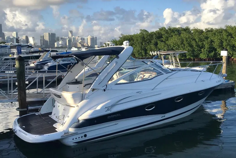 Slide: The Image of 2007 Doral Intrigue yacht docked at marina with city skyline in background. - 2
