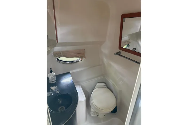 Slide: The Image of Compact bathroom in 2007 Doral Intrigue boat with sink, toilet, and mirror. - 21
