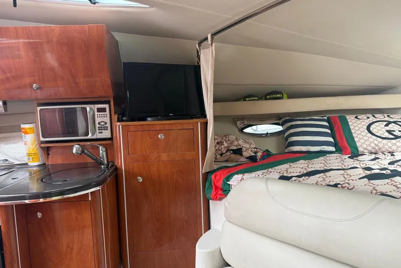 Slide: The Image of Interior of a 2007 Doral Intrigue boat with kitchenette and cozy sleeping area. - 22