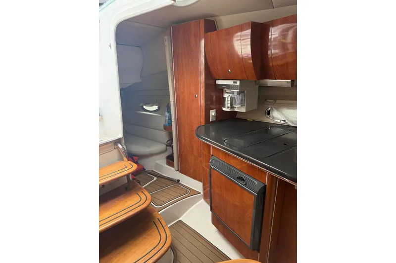 Slide: The Image of 2007 Doral Intrigue boat interior with wooden cabinetry and compact kitchen area. - 23