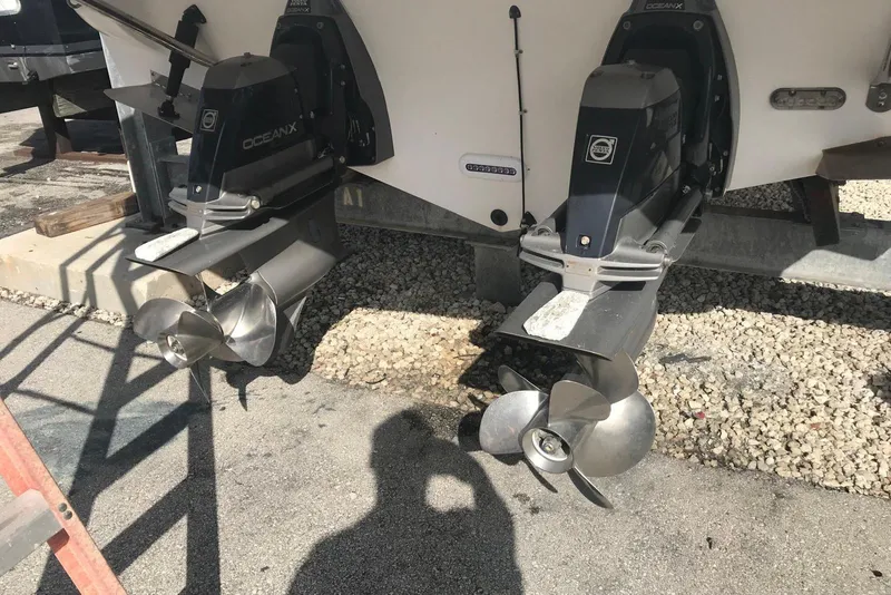 Slide: The Image of 2007 Doral Intrigue boat with dual OceanX outdrives, parked on gravel. - 40