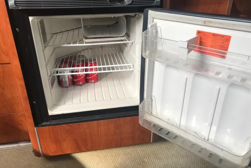 Slide: The Image of Open fridge in 2007 Doral Intrigue boat with soda cans inside. - 44