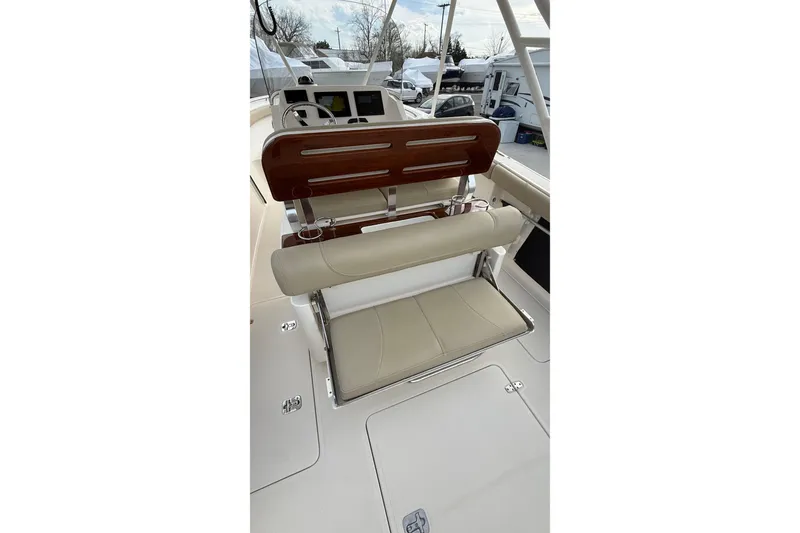 Slide: The Image of 2016 Pursuit S 280 Sport boat interior with beige seating and wooden accents. - 12