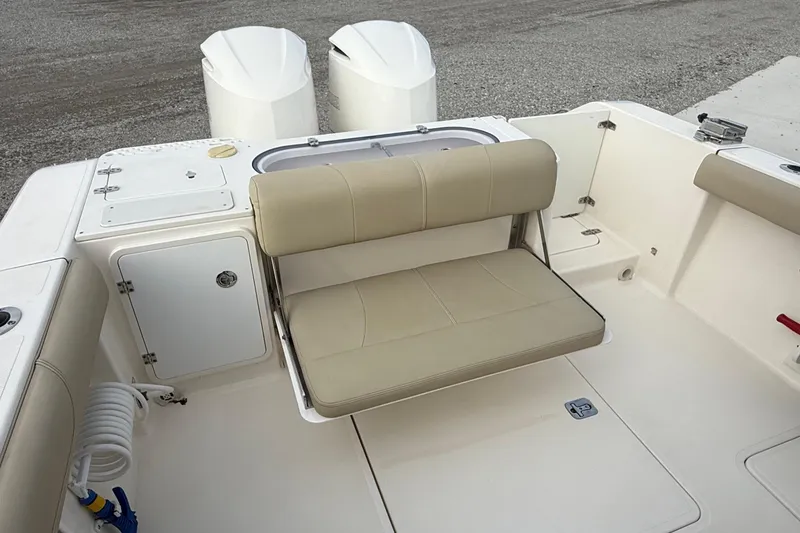 Slide: The Image of 2016 Pursuit S 280 Sport boat interior with beige seating and storage compartments. - 16