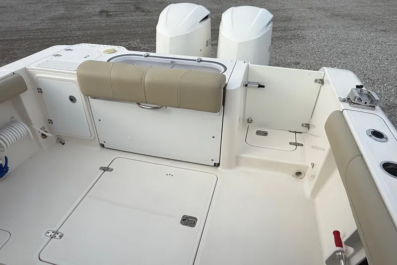 Slide: The Image of 2016 Pursuit S 280 Sport boat interior with beige seating and dual outboard motors. - 19