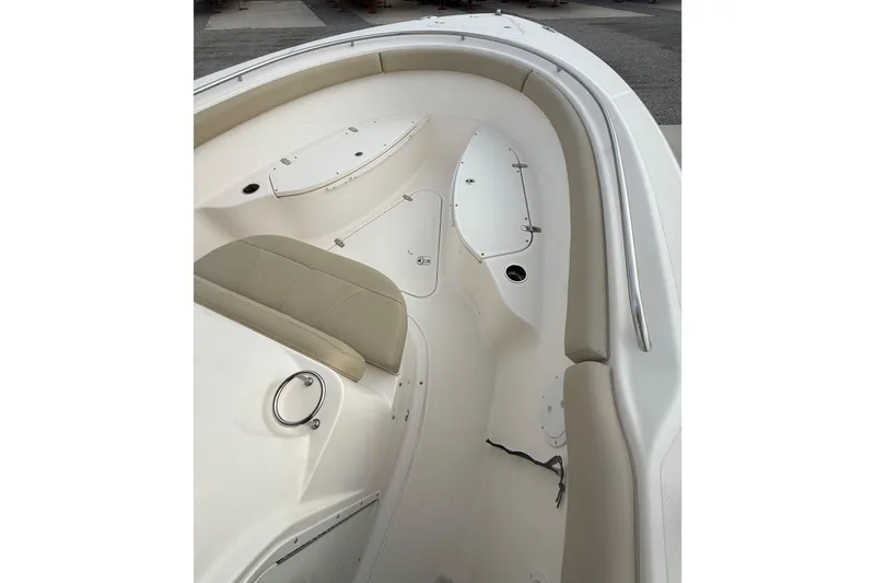 Slide: The Image of Interior view of a 2016 Pursuit S 280 Sport boat, featuring beige seating and storage compartments. - 26