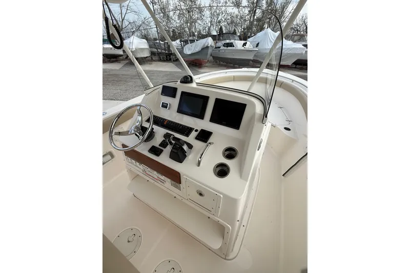 Slide: The Image of 2016 Pursuit S 280 Sport boat helm with steering wheel, controls, and navigation screens. - 34