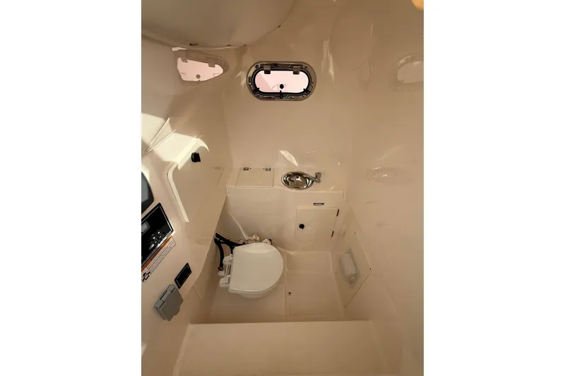 Slide: The Image of Interior of 2016 Pursuit S 280 Sport boat, featuring compact marine bathroom amenities. - 38