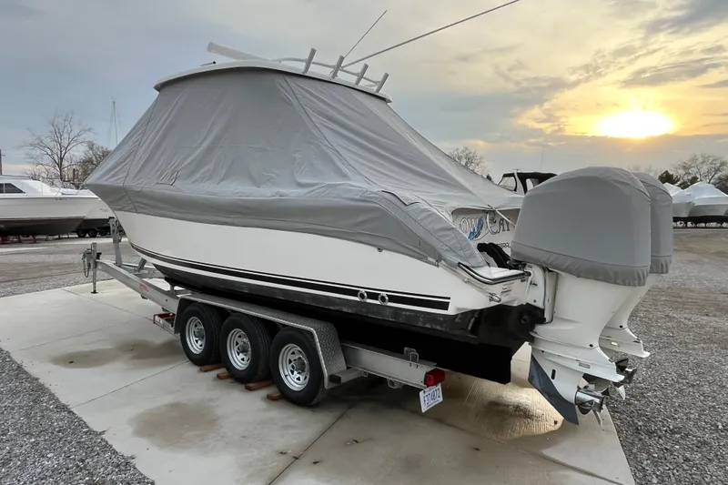 Slide: The Image of 2016 Pursuit S 280 Sport boat covered on trailer at sunset. - 52