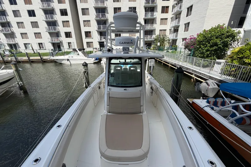 Slide: The Image of 2016 Boston Whaler 330 Outrage docked near waterfront buildings, featuring Garmin equipment. - 10