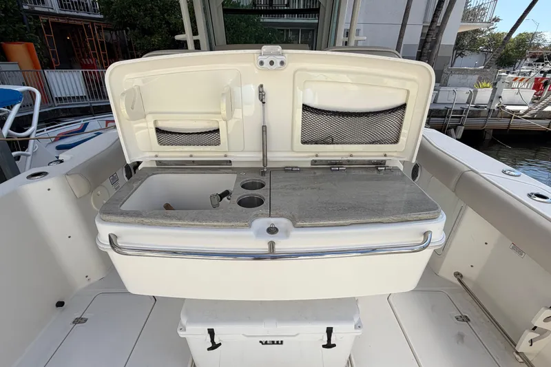 Slide: The Image of 2016 Boston Whaler 330 Outrage boat with open storage compartment and sink. - 8