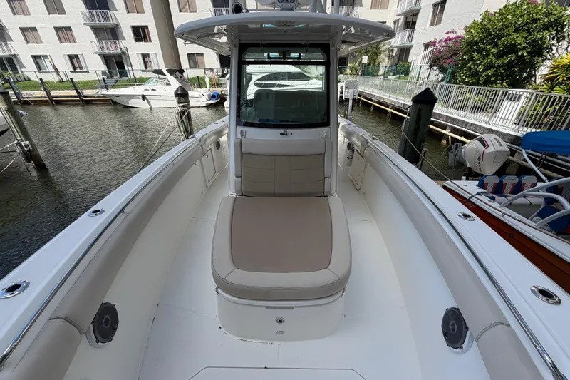 Slide: The Image of 2016 Boston Whaler 330 Outrage boat interior with seating, docked near waterfront buildings. - 9