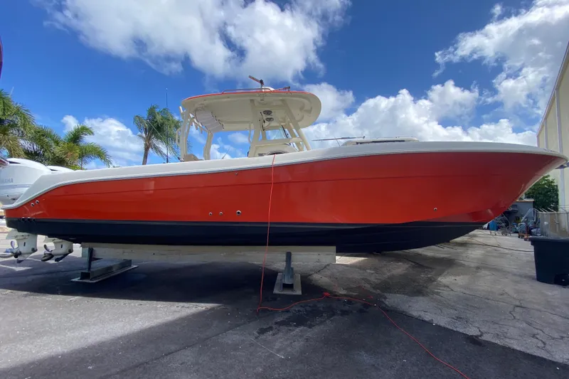 The Image of 2006 Hydra-Sports Vector 3300 CC boat with red hull, docked under a blue sky. - 0