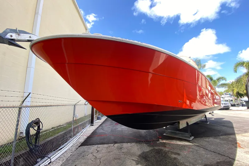 Slide: The Image of 2006 Hydra-Sports Vector 3300 CC boat with vibrant red hull, docked outdoors. - 19