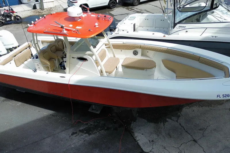 Slide: The Image of 2006 Hydra-Sports Vector 3300 CC boat with red and white exterior, docked on pavement. - 2