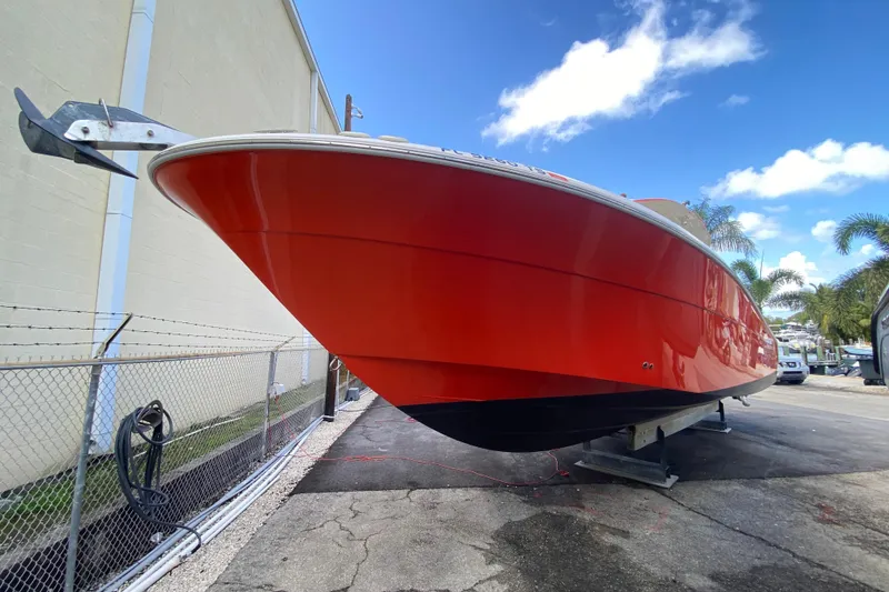 Slide: The Image of 2006 Hydra-Sports Vector 3300 CC boat with vibrant red hull, docked outdoors. - 22
