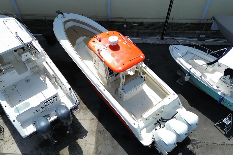 Slide: The Image of 2006 Hydra-Sports Vector 3300 CC boat with orange canopy, docked between two other boats. - 8