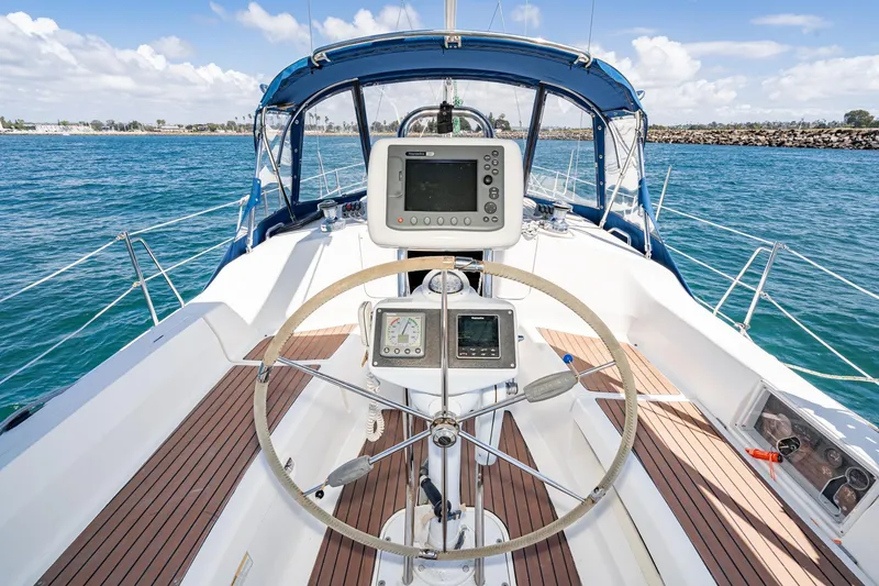Slide: The Image of Cockpit view of a 2007 Hunter 38 sailboat with navigation equipment and blue canopy. - 11