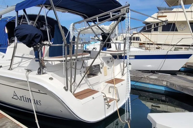 Slide: The Image of 2007 Hunter 38 sailboat docked, featuring blue canopy and sleek design. - 13