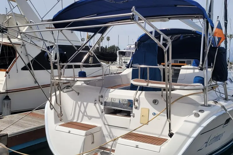 Slide: The Image of 2007 Hunter 38 sailboat docked, featuring a blue canopy and stainless steel railings. - 14