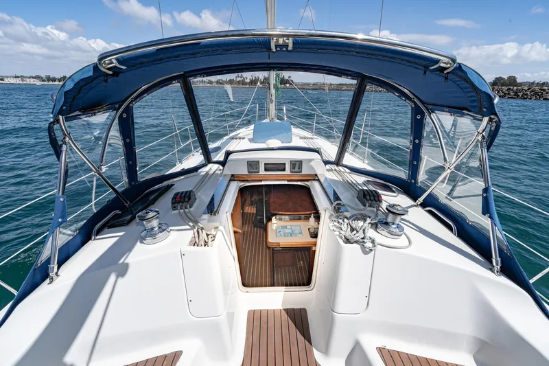Slide: The Image of 2007 Hunter 38 sailboat cockpit with blue canopy, open cabin, and ocean view. - 29