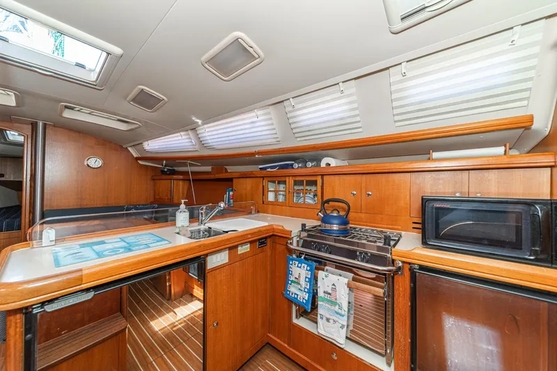 Slide: The Image of Interior of a 2007 Hunter 38 sailboat kitchen with wooden cabinetry and modern appliances. - 33