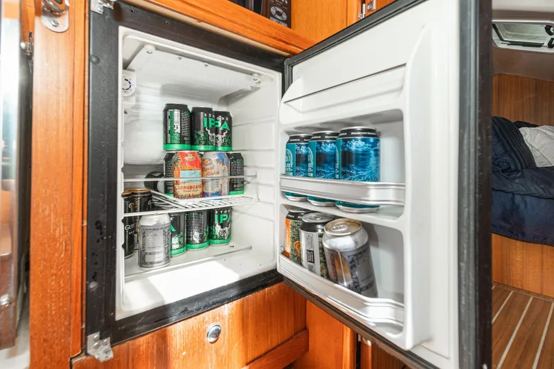 Slide: The Image of Mini fridge stocked with various beer cans inside a 2007 Hunter 38 sailboat. - 34