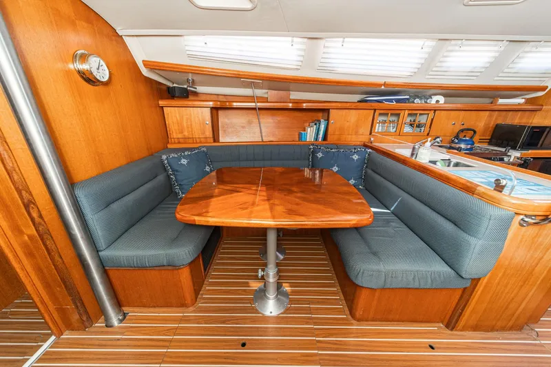 Slide: The Image of Interior of 2007 Hunter 38 sailboat with wooden dining area and cushioned seating. - 37