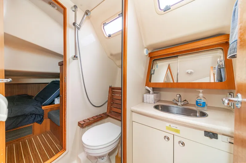 Slide: The Image of Interior of 2007 Hunter 38 yacht featuring bathroom and cozy cabin with bed. - 45