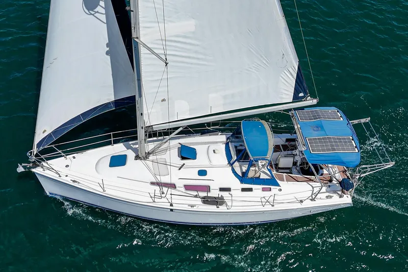 Slide: The Image of 2007 Hunter 38 sailboat with solar panels, sailing on clear blue water. - 8