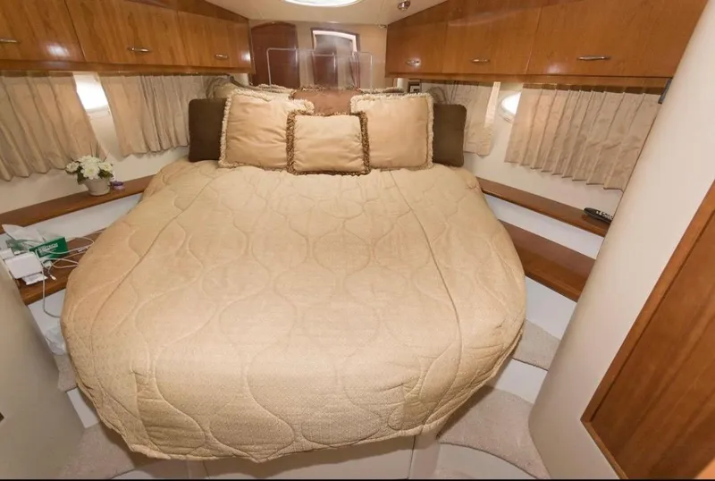 Slide: The Image of Cozy cabin interior of 2005 Carver 360 Sport Sedan with patterned bedding and wooden cabinets. - 15